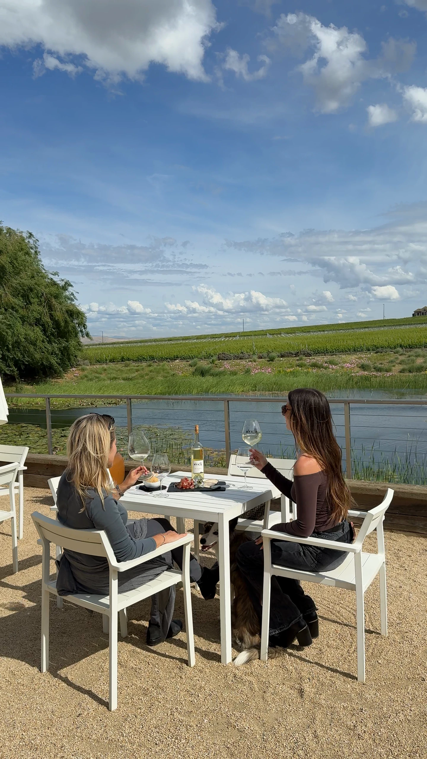 Two women enjoy wine tasting outdoors at Wrath winery on River Road in Santa Lucia Highlands, Monterey County.