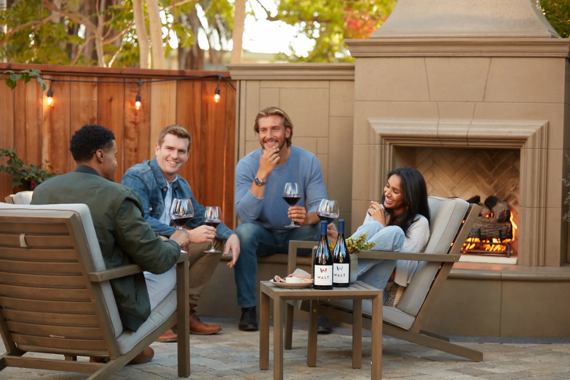 Friends enjoy wine by a fireplace at Walt Wines.