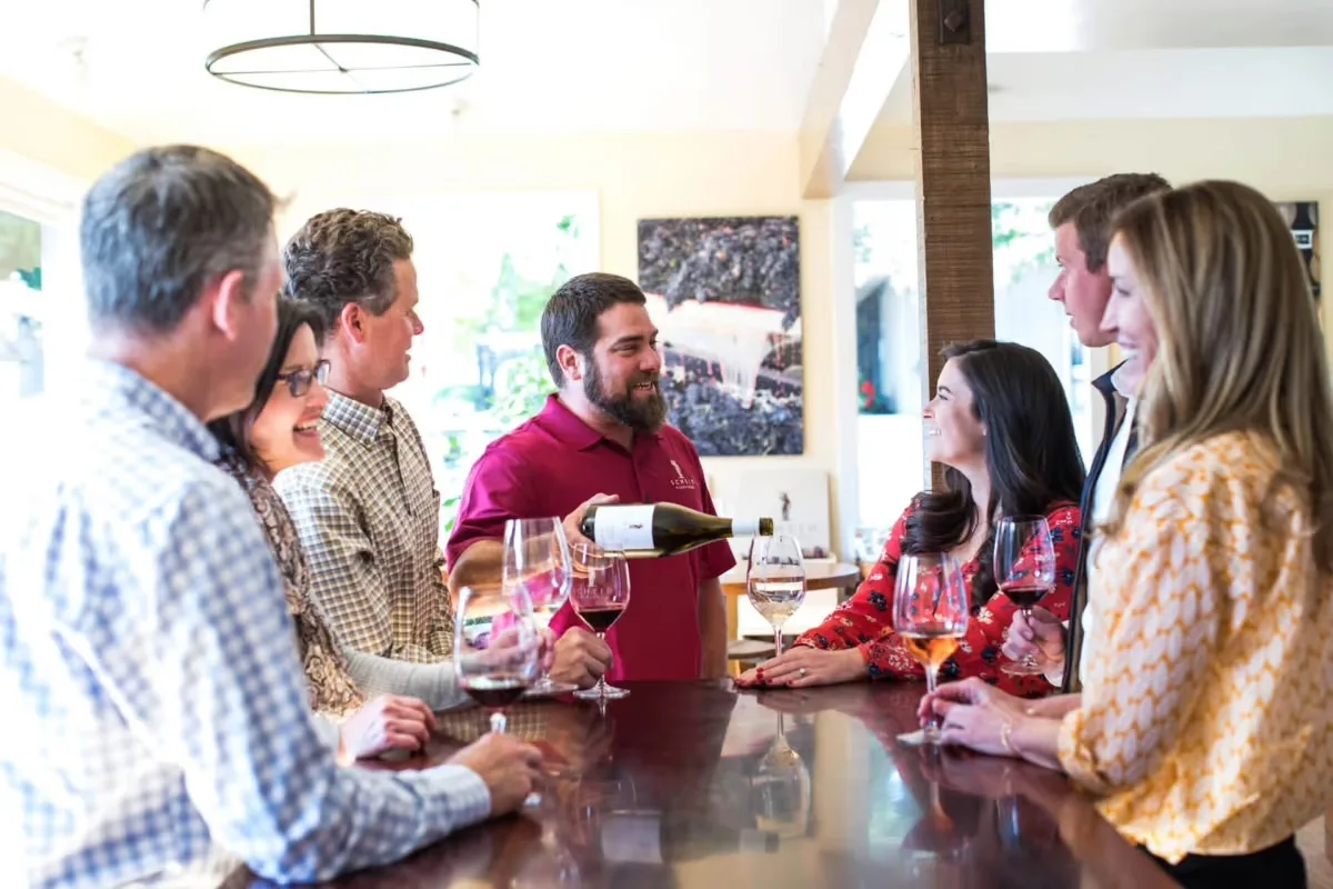 Scheid Vineyards tasting room guests in Carmel, CA, enjoy wine pouring.