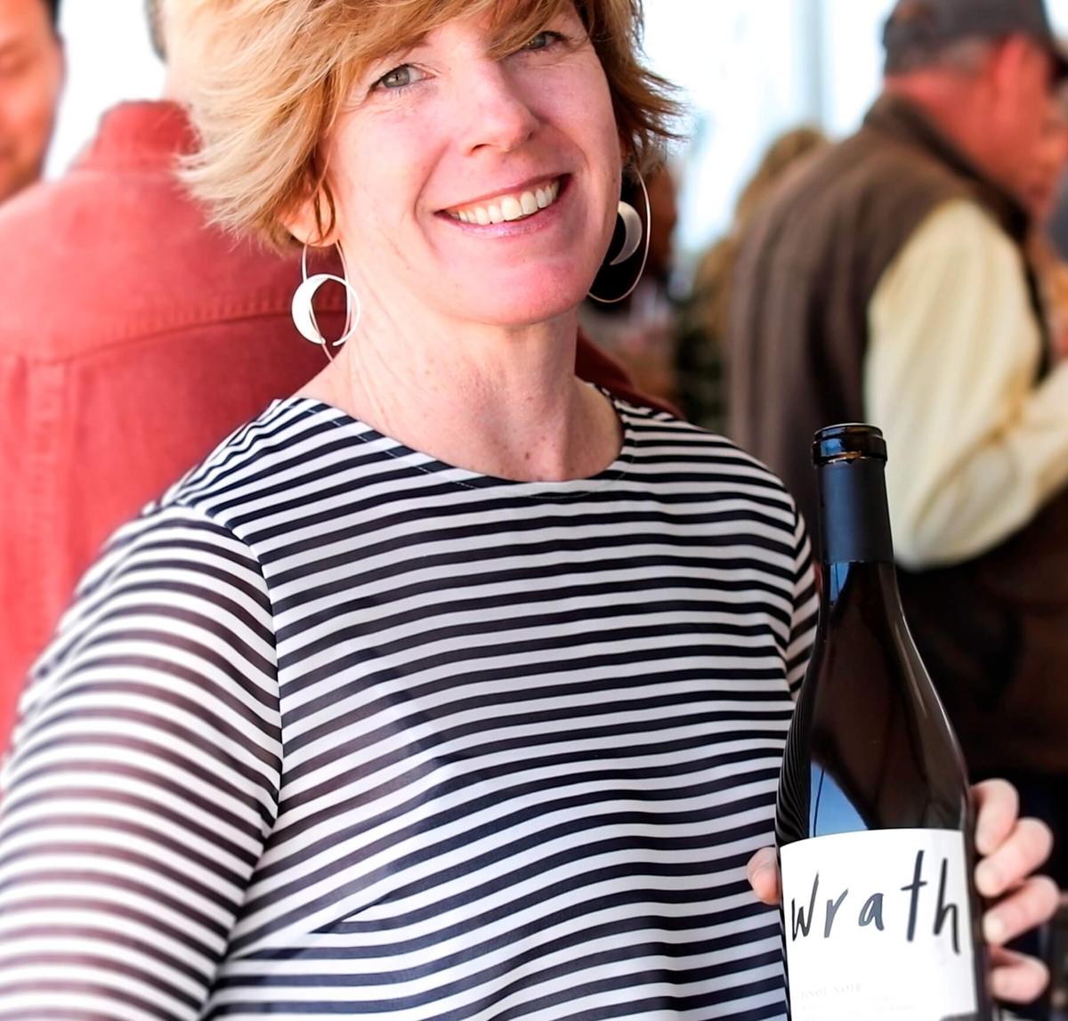 Woman winemaker holding a bottle of Wrath wine in Santa Lucia Highlands.