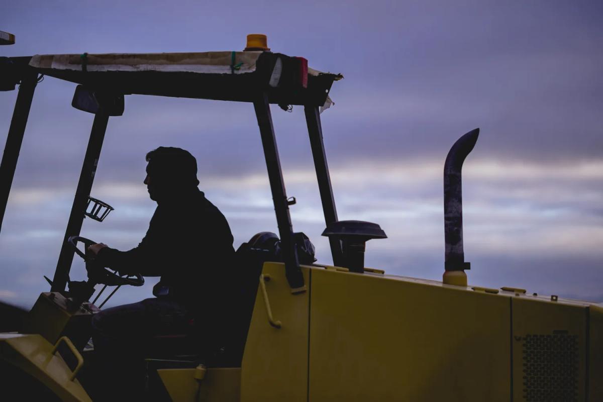 Farm worker on a tractor in the Santa Lucia Highlands during harvest.