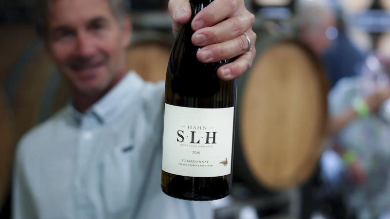 Man holding Hahn SLH Chardonnay in Santa Lucia Highlands winery.