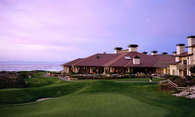Golf course and clubhouse overlooking the ocean at sunset at Pebble Beach, California.