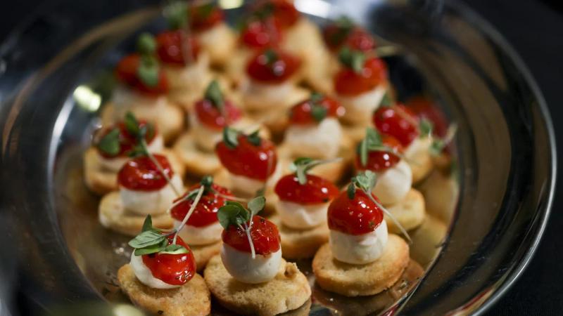 Trio crostini with cherry tomatoes and mozzarella on a silver platter.