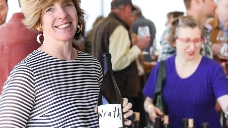 Woman holding Wrath wine bottle at Santa Lucia Highlands tasting event.