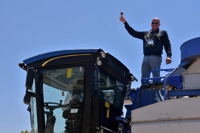 Man with wine glass on McIntyre Wines harvester, Santa Lucia Highlands, Monterey County.