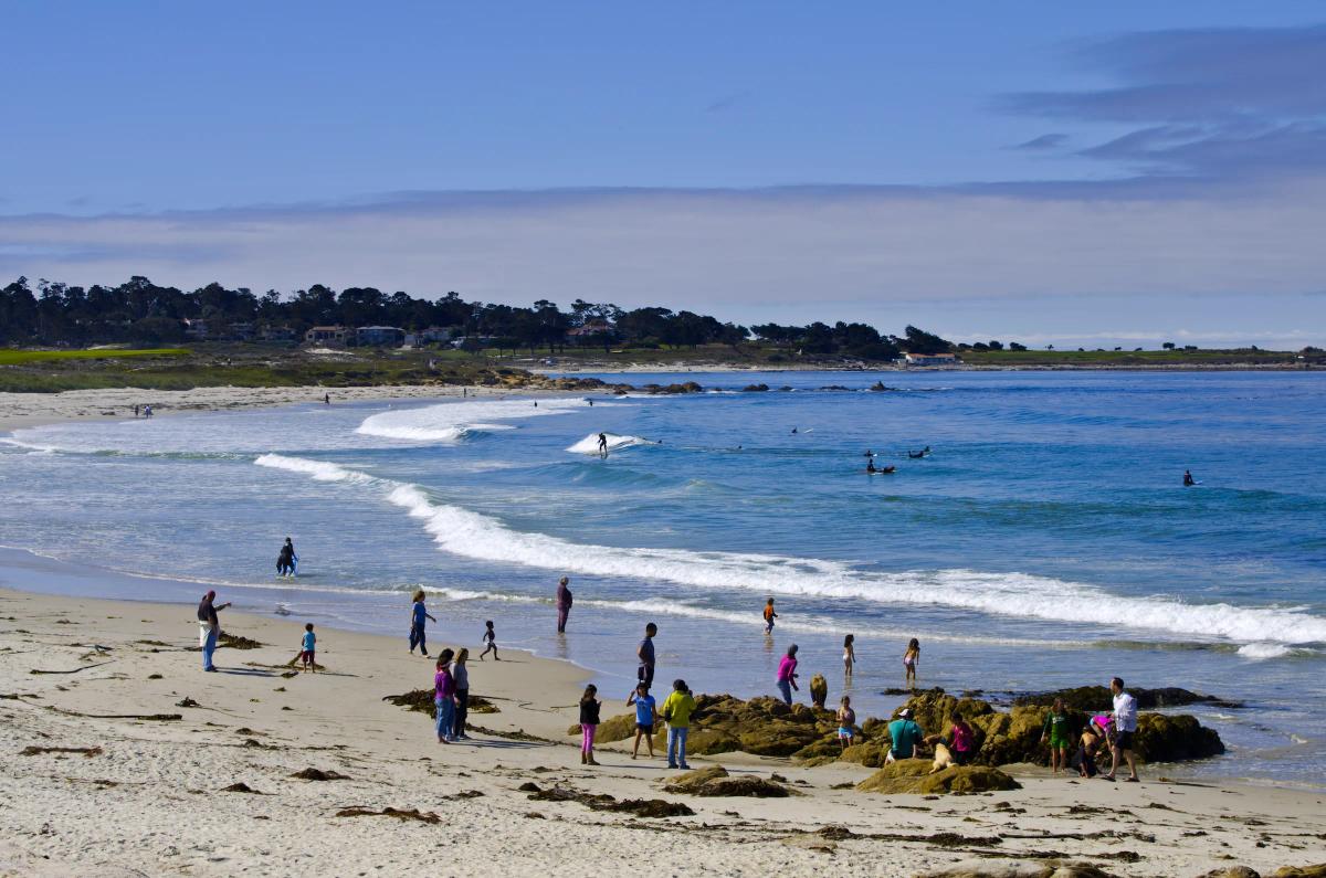 People enjoy surfing and relaxing on Asilomar State Beach in Pacific Grove, near Santa Lucia Highlands.