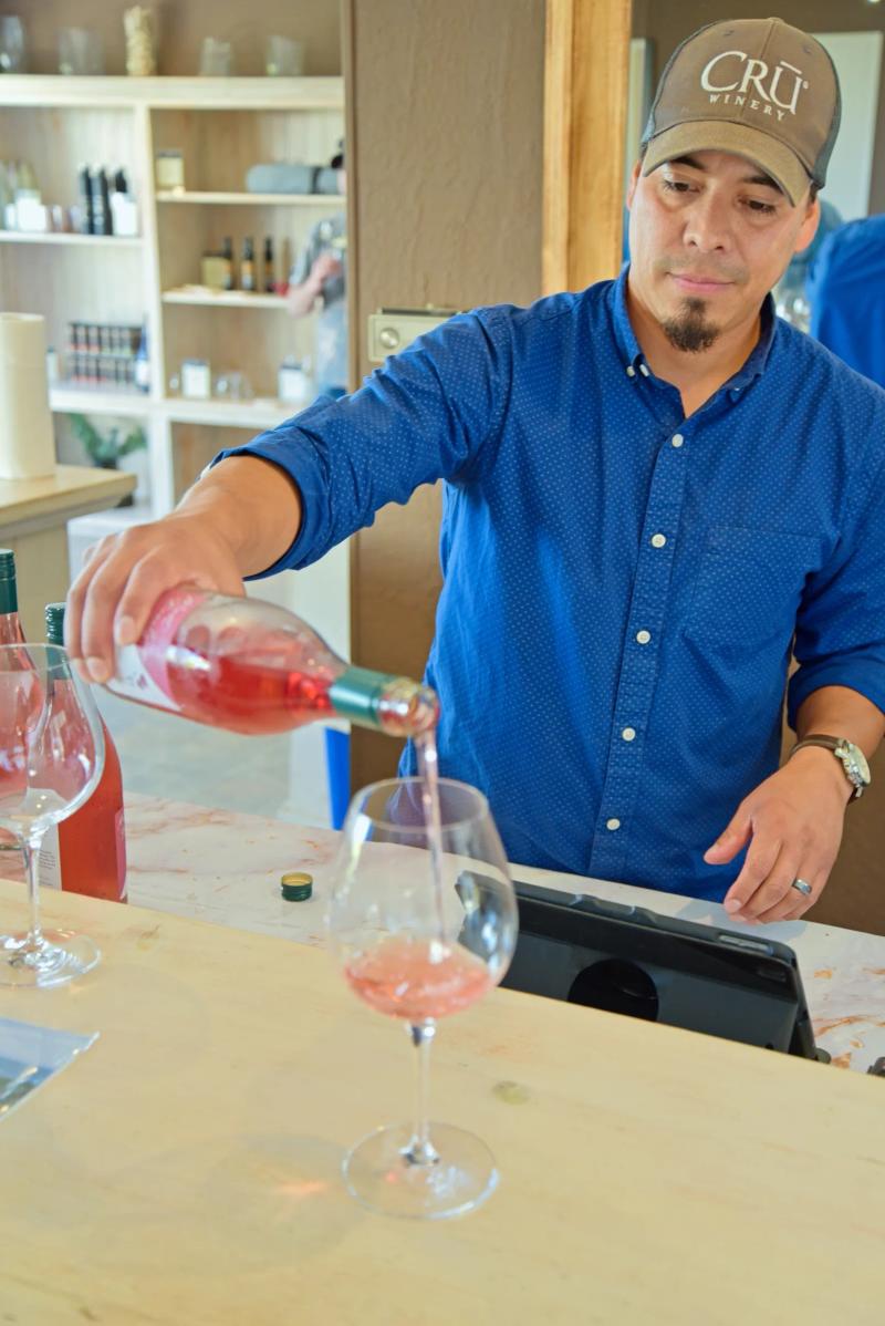 Sommelier pours rosé at Cru Winery, Santa Lucia Highlands, Monterey County.