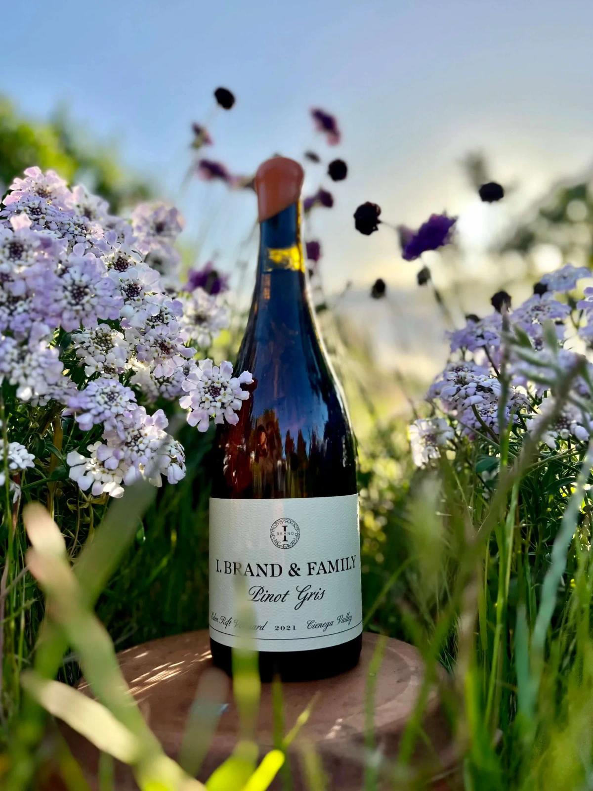 I. Brand & Family Pinot Gris bottle surrounded by wildflowers in Santa Lucia Highlands.