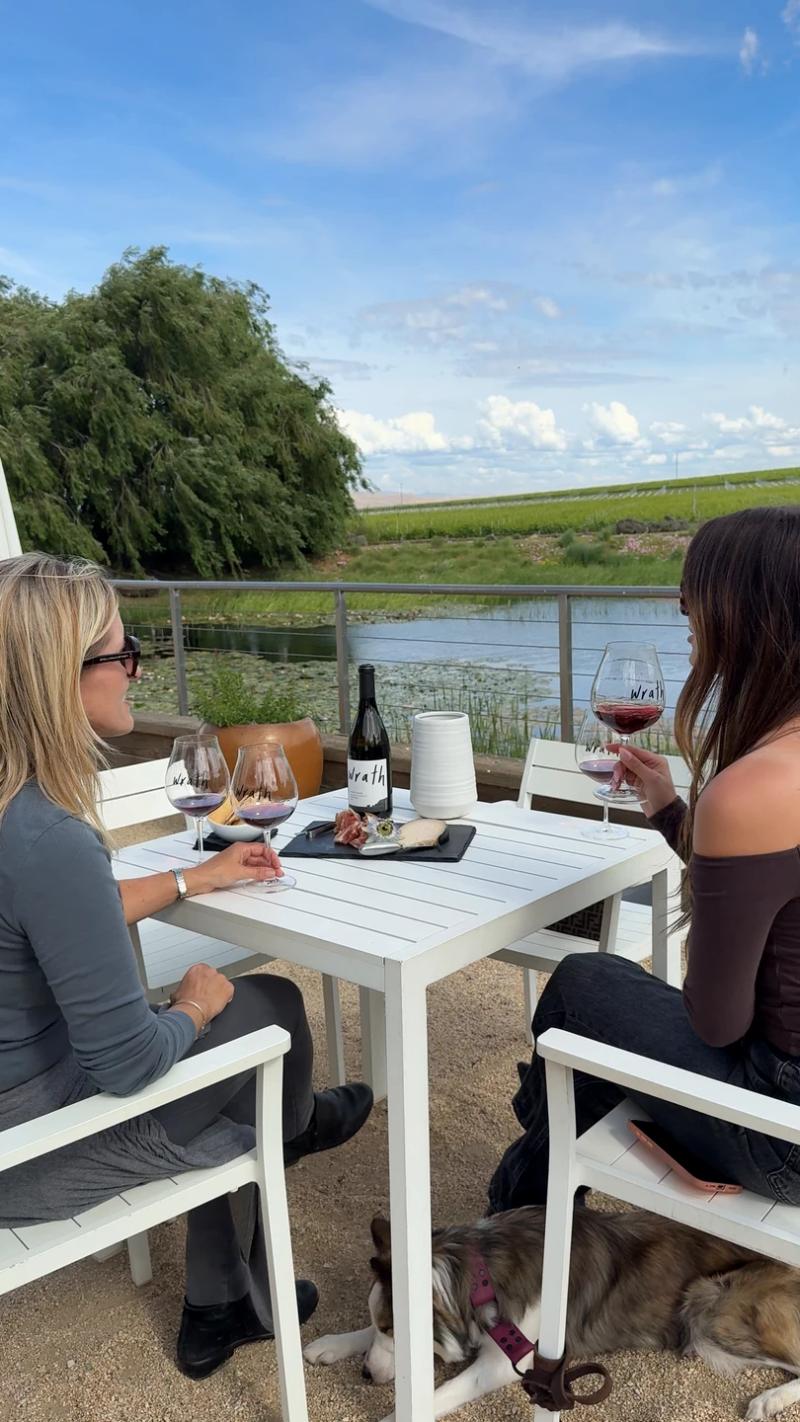 Two women enjoy wine and charcuterie at a table overlooking vineyards at Scratch Wines, a Salinas winery in Santa Lucia Highlands, California.