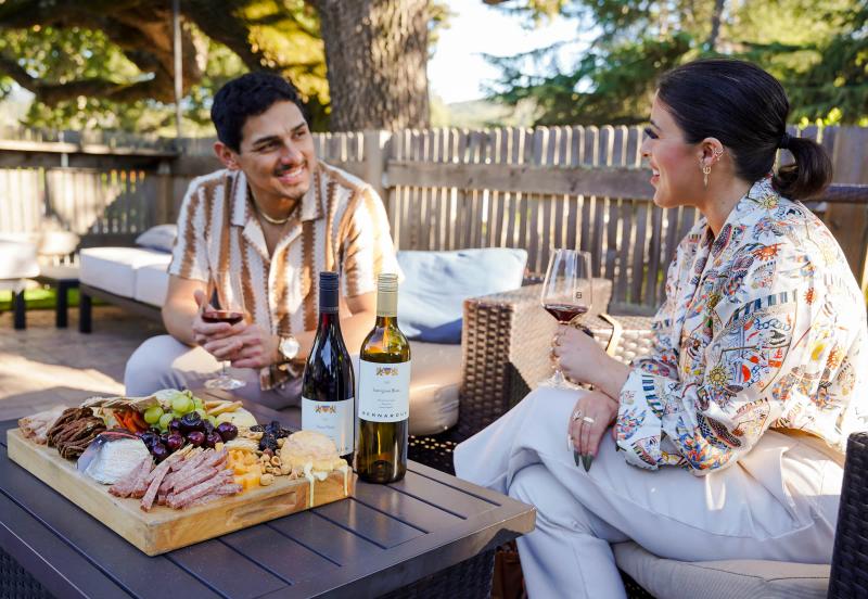 Couple enjoying wine and charcuterie on a patio at Bernardus Winery in Carmel Valley.
