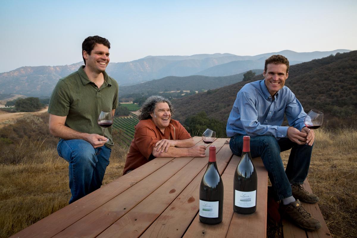 Jeff, Gary, and Mark Pisoni with wine bottles and vineyard views in Santa Lucia Highlands.