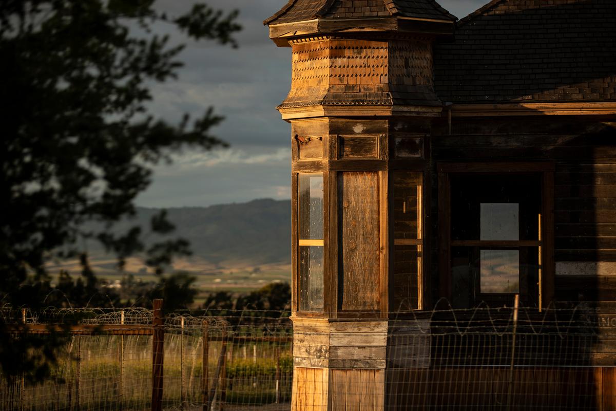 Historic wooden building in Santa Lucia Highlands, California, with vineyard views.