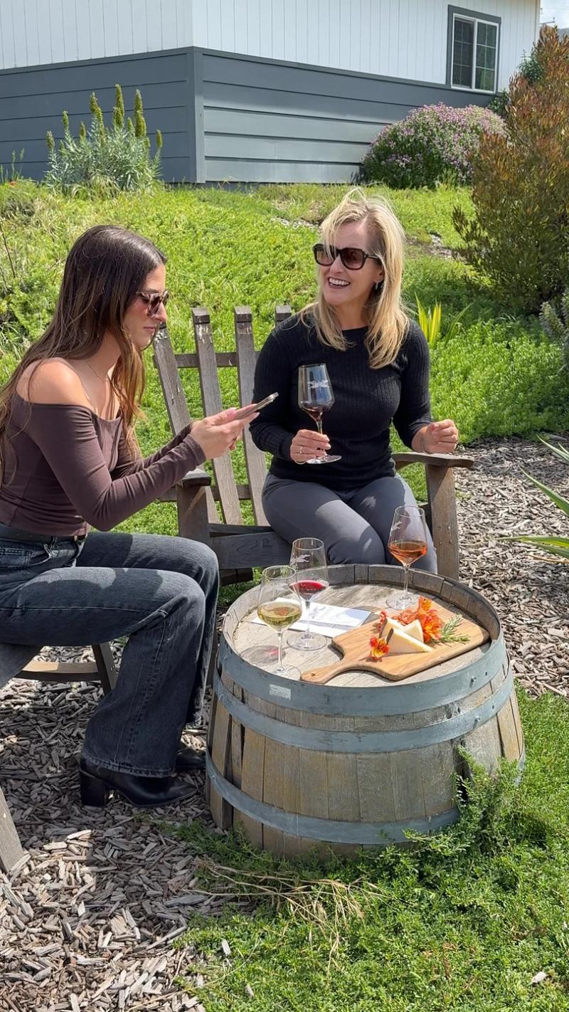 Two women enjoy wine and cheese tasting outdoors at Odonata Wines, a Salinas winery on River Road in Santa Lucia Highlands