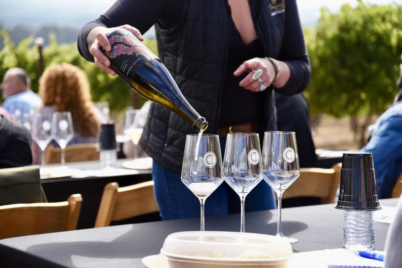 Sommelier pours wine at Caraccioli-Escolle Vineyard, Santa Lucia Highlands.