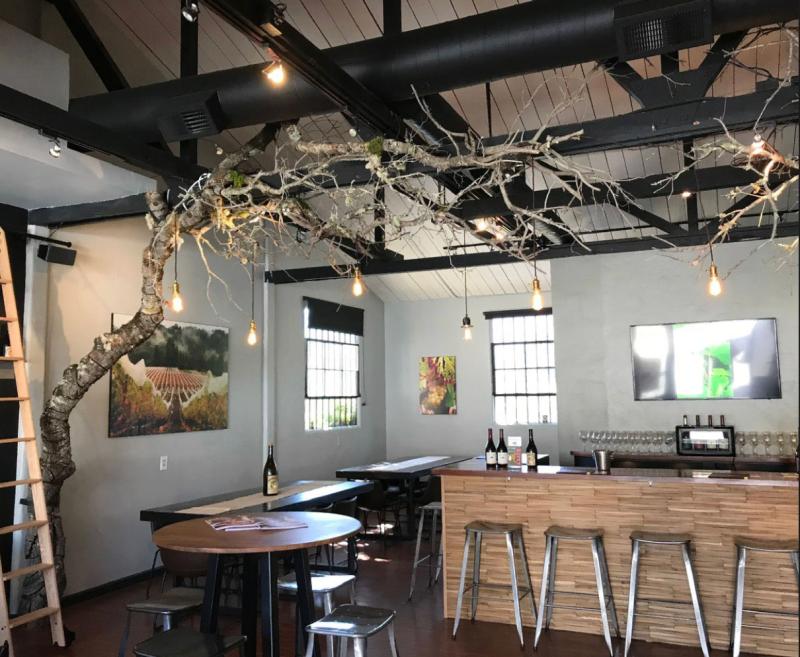 Interior of Windy Oaks tasting room in Carmel Valley, with a tree branch art installation.