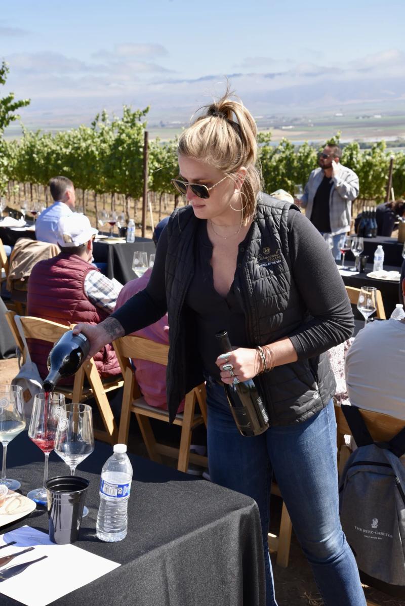 Sommelier pours wine at Caraccioli-Escolle Vineyard, Santa Lucia Highlands.