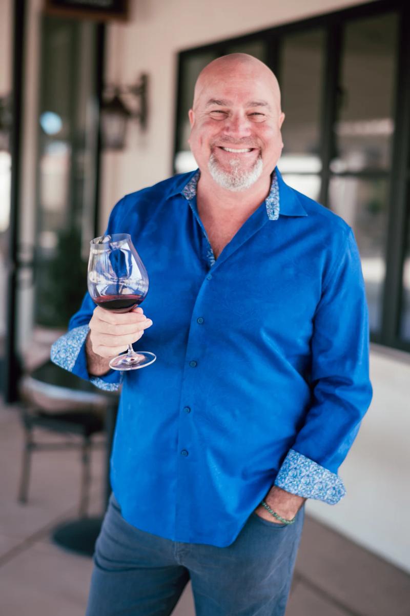 Dan Kosta of Dan Kosta Winery, Santa Lucia Highlands, holding a glass of red wine.